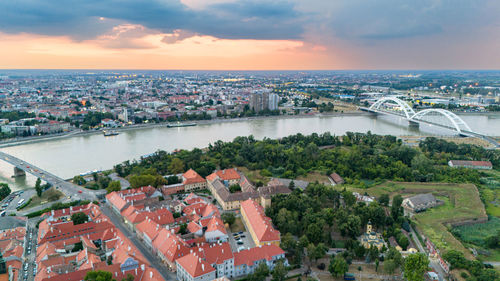 High angle view of townscape by sea against sky during sunset