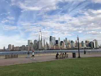 People in city against cloudy sky