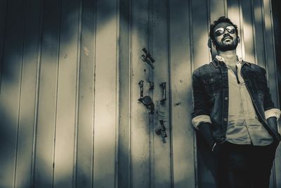 Young man standing against wall