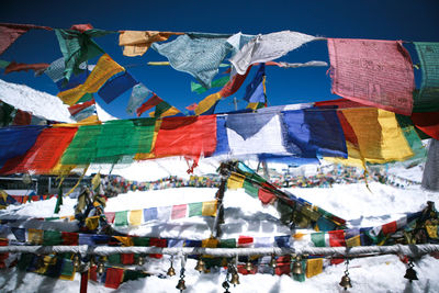 Low angle view of multi colored flags hanging against sky