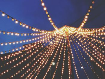 Low angle view of illuminated blue sky at night