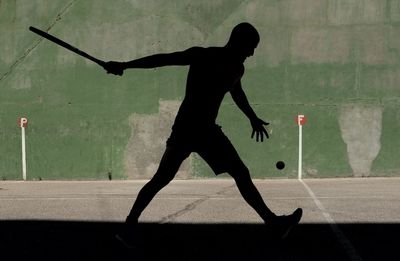 Silhouette man playing at court 