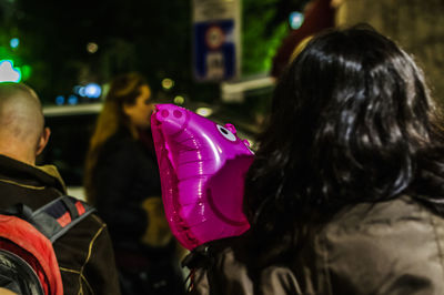 Rear view of woman with pink balloons