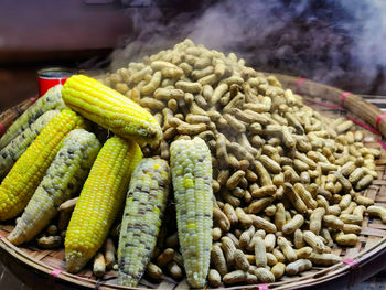 Steaming hot peanuts and corn on a market stall in yangon, myanmar.