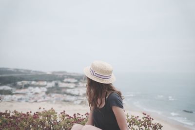 Woman looking at sea against sky