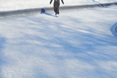 Low section of man walking on snow