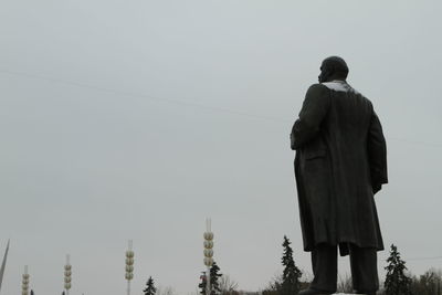 Rear view of men standing against clear sky