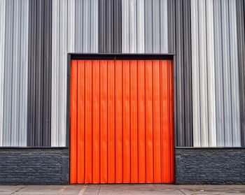 Closed orange metal door of building