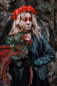 Closeup portrait of calavera catrina. young woman with sugar skull makeup and red flowers. dia 