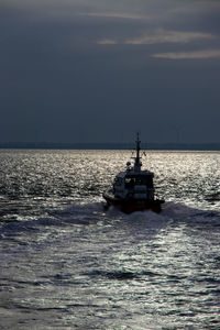 Ship sailing in sea against sky during sunset