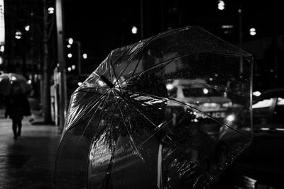 Close-up of wet walking on illuminated street during rainy season