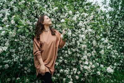 Beautiful girl in blooming apple tree aroma of flowers outdoor nature