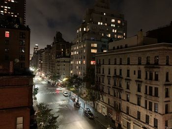 Cars on road amidst buildings in city at night