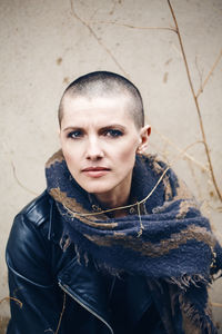 Portrait of woman sitting against wall