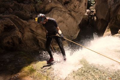 Full length of man canyoneering