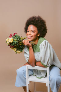 Portrait of young woman sitting on sofa at home