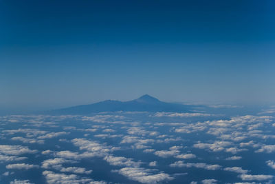 Scenic view of cloudscape and mountains against blue sky