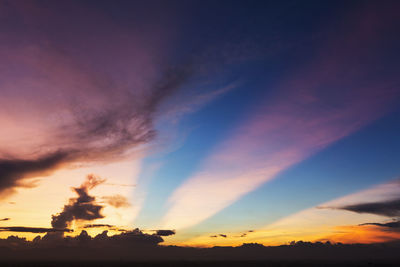 Low angle view of silhouette trees against dramatic sky