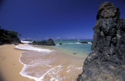 Scenic view of rock formations in sea against sky