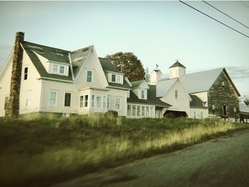 Houses by buildings against sky