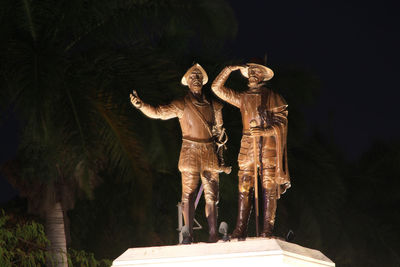 View of statue against trees at night