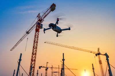 Low angle view of cranes against sky