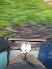 Low section of man standing at entrance of train