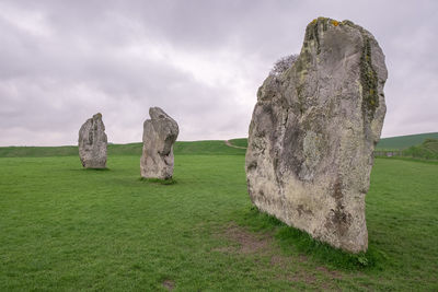 Stone wall on field against sky