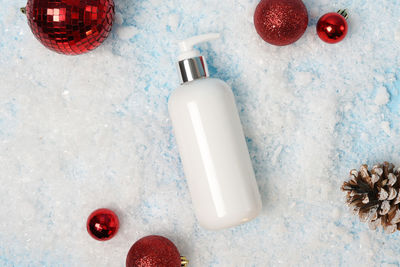 Cosmetic product lotion or shampoo on white christmas background with snow 