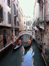 Gondolas at canal along buildings