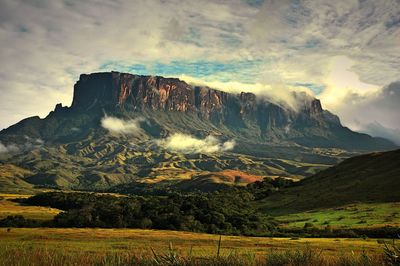 Low angle view of rocky mountains against cloudy sky at mt roraima