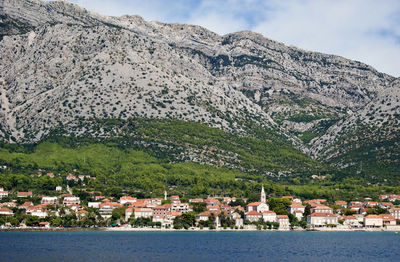 Croatian coastline. view of townscape by mountain against sky.