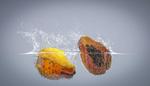 Close-up of berries on water against white background