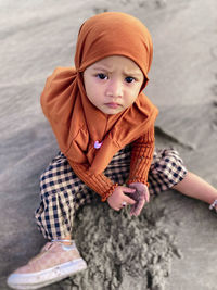 Portrait of young woman sitting on rock