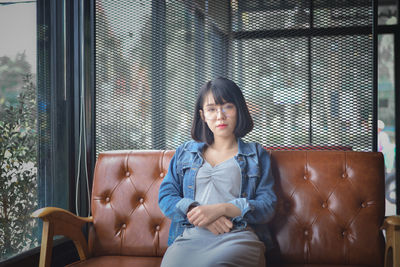 Portrait of young woman sitting on sofa