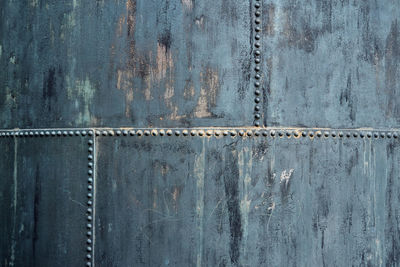 Part of an old storage container made of riveted iron plates, used and dirty, pattern, texture