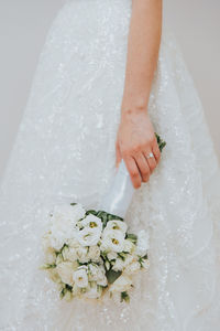 Midsection of woman with bouquet