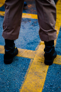 Low section of man standing on road