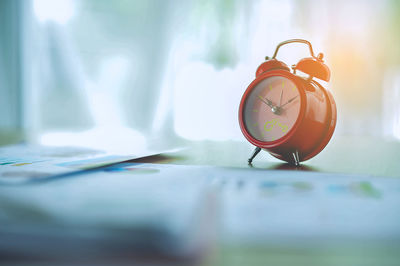 Close-up of red clock on table