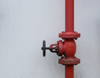 Close-up of red pipe against white wall