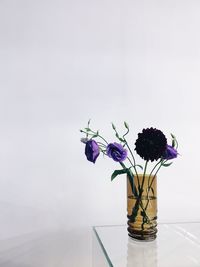 Close-up of flower vase on table against wall 