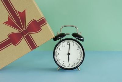 Close-up of alarm clock against blue background