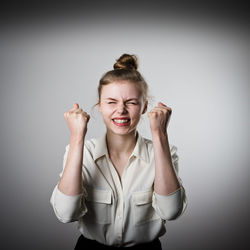 Portrait of a smiling young woman against gray background