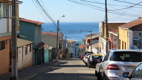 Cars on street in city against sky