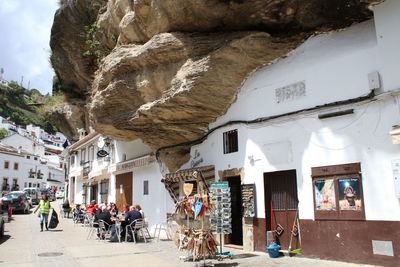 People on street by buildings in city