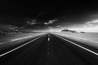 Road leading towards mountain against sky