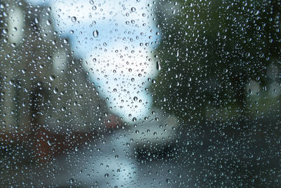 Full frame shot of rain drops on car window