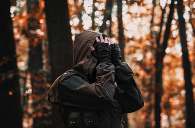 Midsection of woman standing in forest during autumn