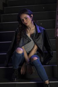 Portrait of smiling young woman sitting on staircase