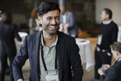 Businessman in blazer laughing at seminar